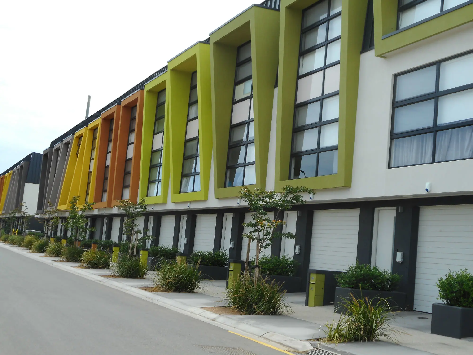 Modern townhouses with window trim in green, orange and yellow.