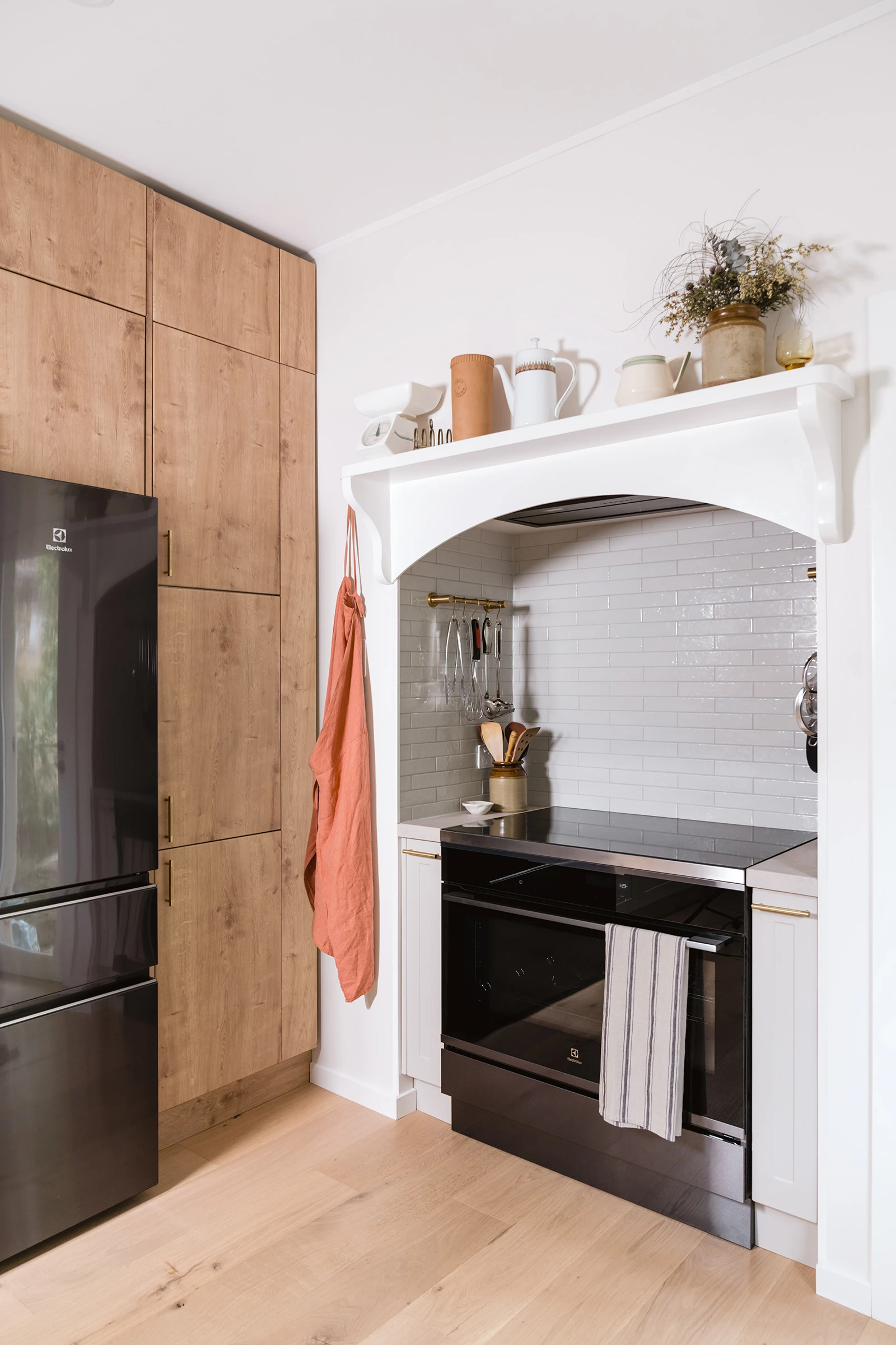Black stove with white rangehood and timber cabinetry