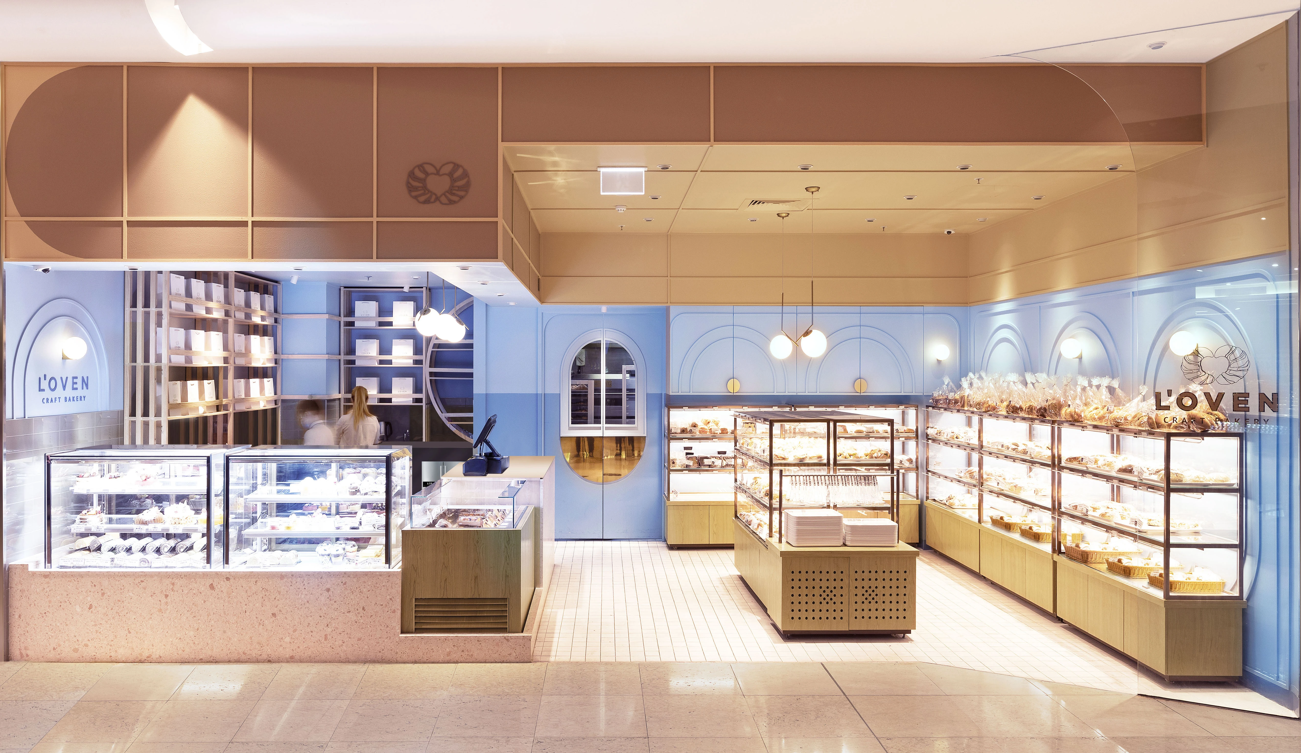 Blue bakery with apricots ceiling and glass cabinets.