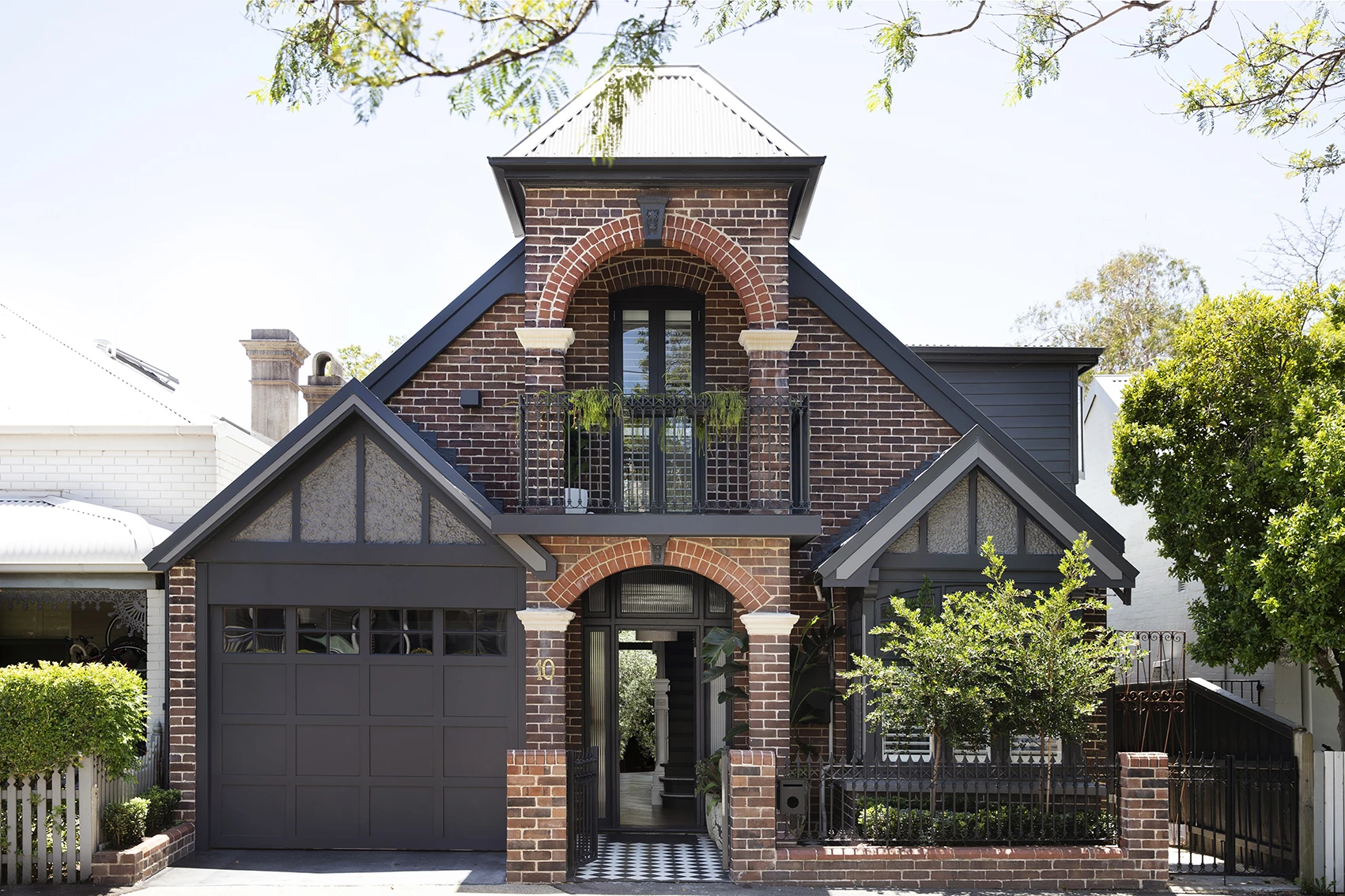 Red brick double-storey house with black trim.