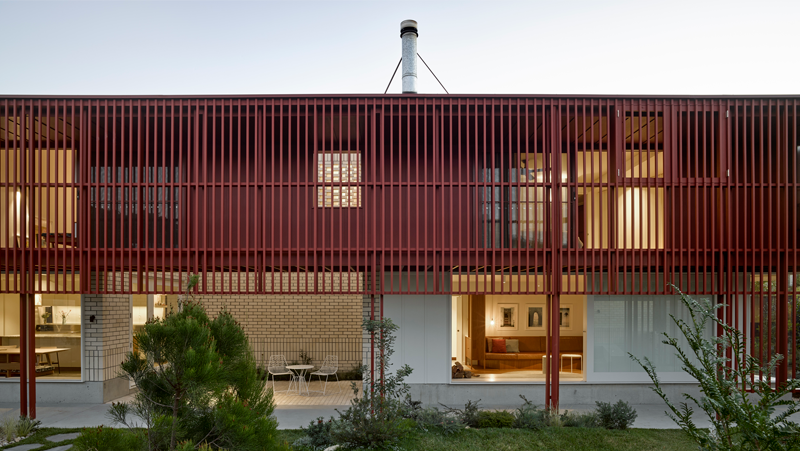 exterior of double storey home with red louvres across the front of the first level