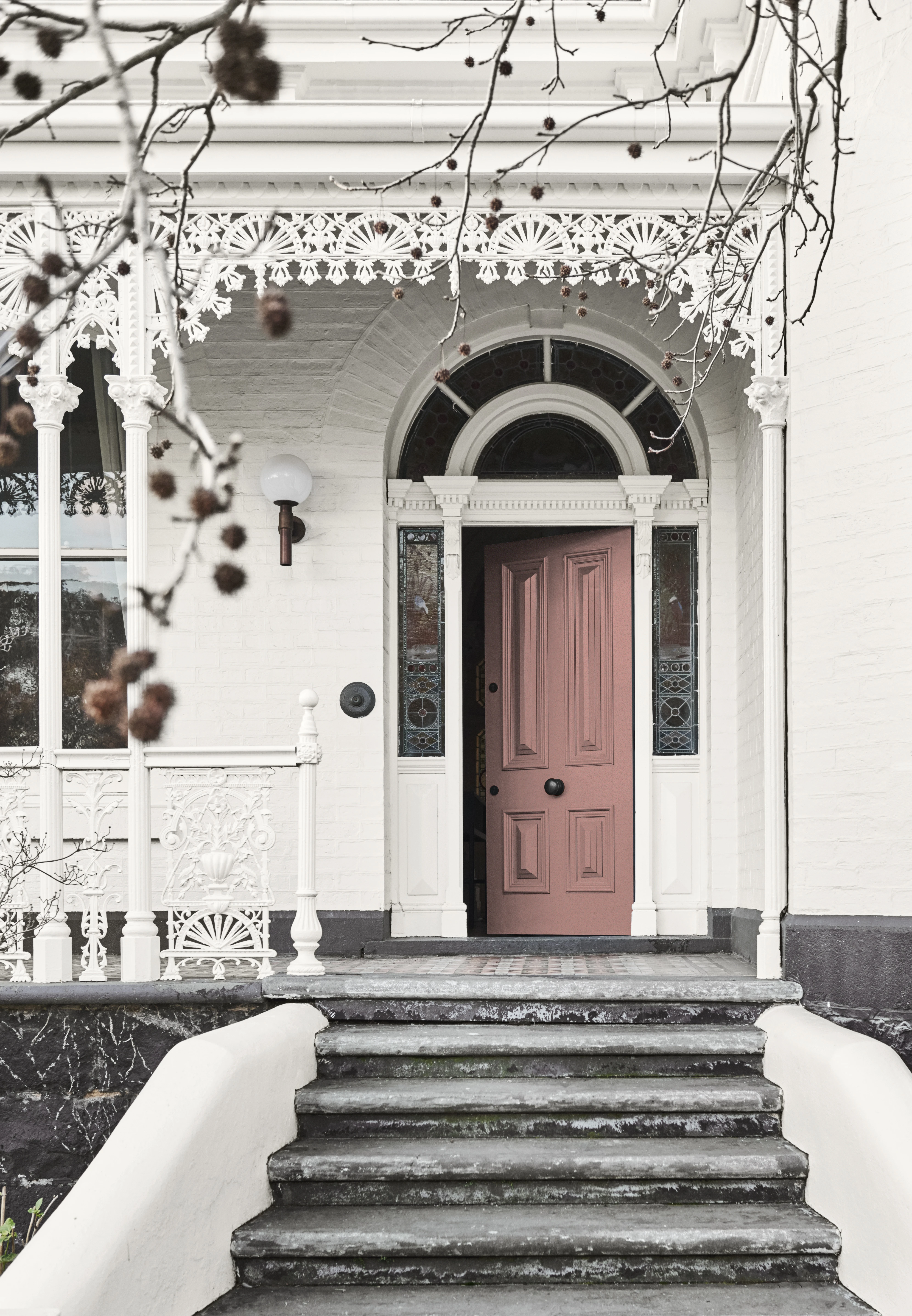 White traditional terrace home with rose gold front door