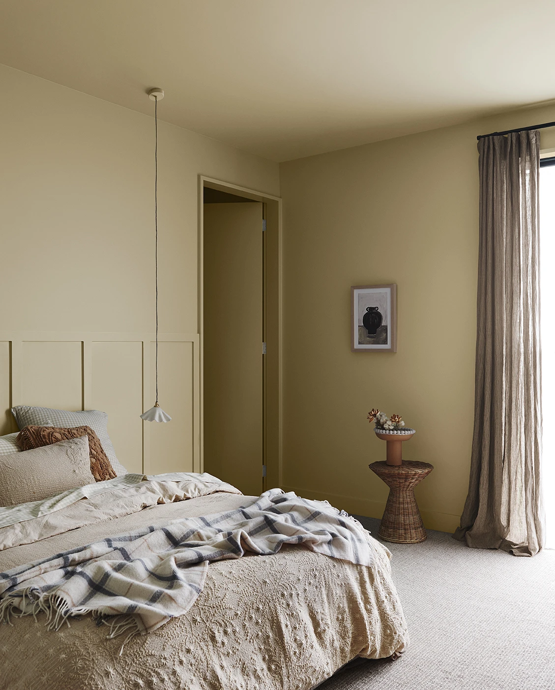 Bedroom with warm beige walls and ceiling and neutral curtains