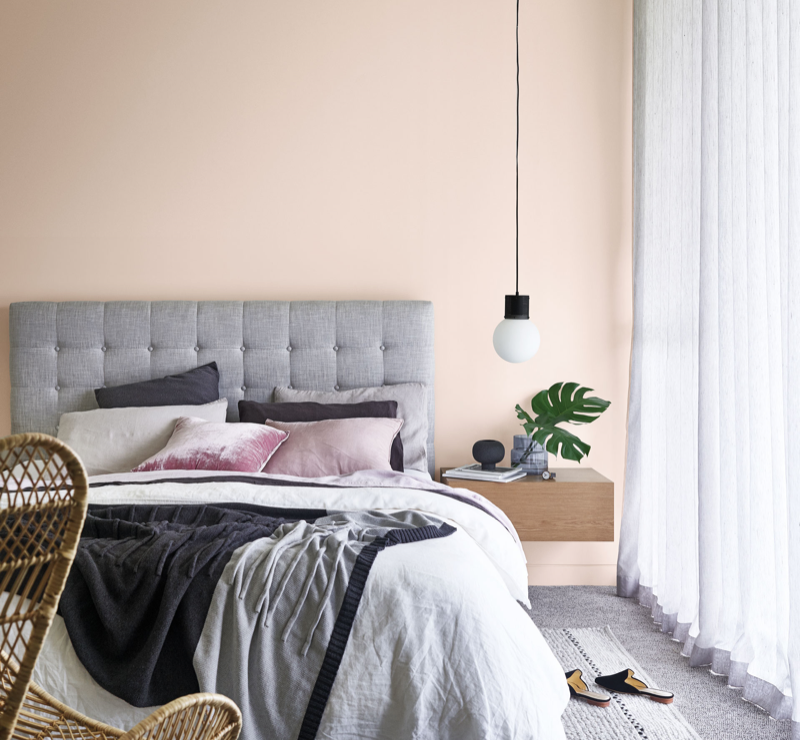 View of grey bed in peach bedroom