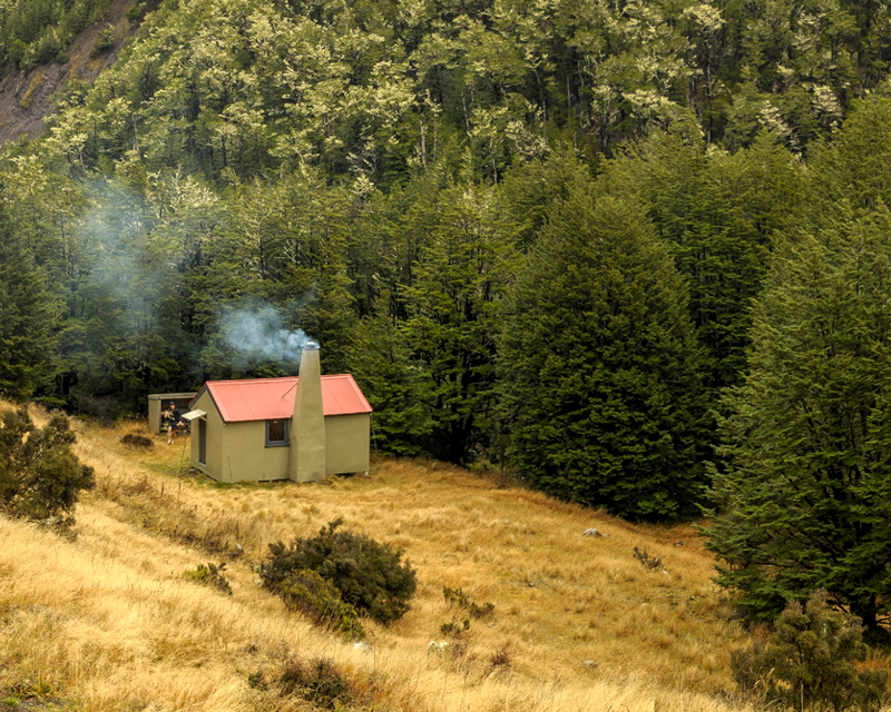 Youngman Stream Hut with smoke coming out of the chimney