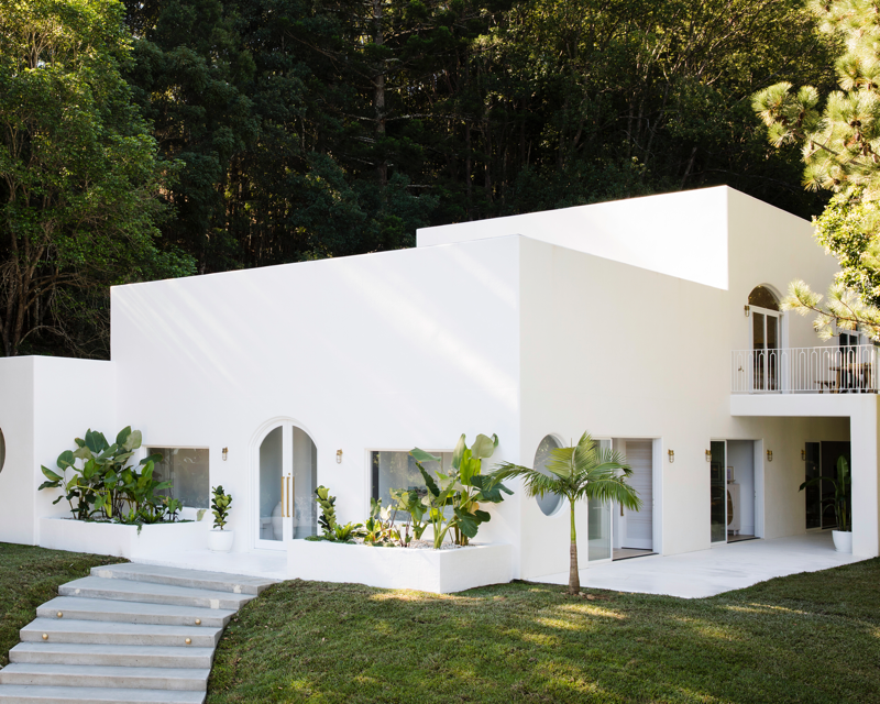 White square home in the Australian bush hinterland featuring stone stairs and entire house painted in Dulux Casper White Quarter™. 