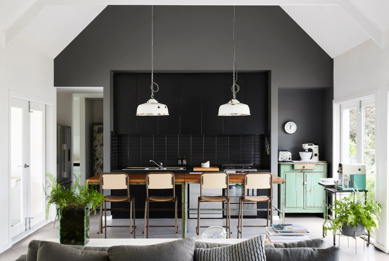 Kitchen and Dining room with grey colour feature wall, white side walls and vaulted ceilings.