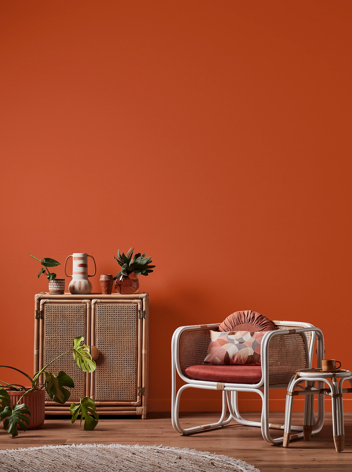 Orange living room with rattan cabinet and chair
