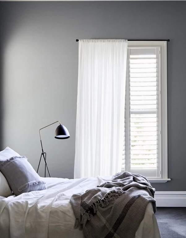 Grey bedroom with white plantation shutters
