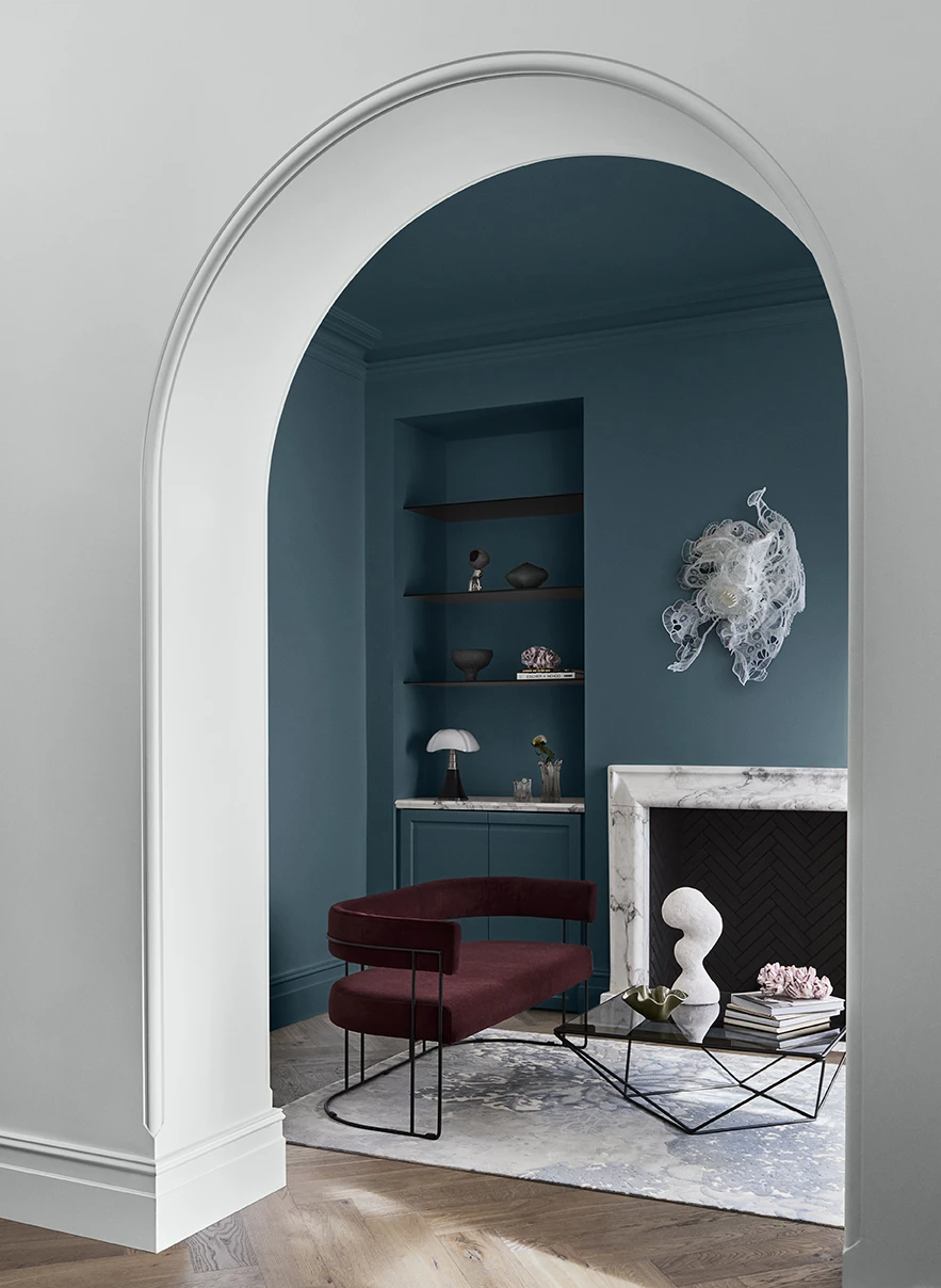 White arched doorway with view to blue living room