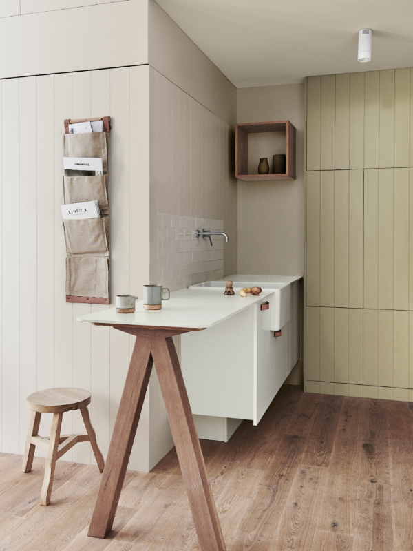 Soft green kitchenette with VJ paneling and timber floorboards