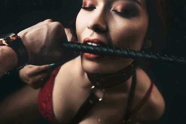 Girl with flogger in mouth