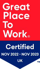 The Great Place To Work logo. Certified November 2022 to November 2023. The logo is is a red and blue background with white writing.