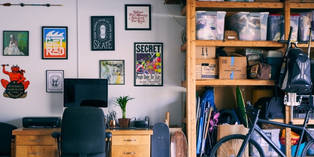 An office with art on the walls, along with storage space nearby