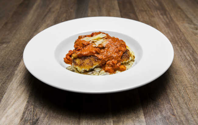 Traditions on the Lake's potato-crusted grouper is topped with red Creole gravy and served on a bed of andouille mushroom risotto.