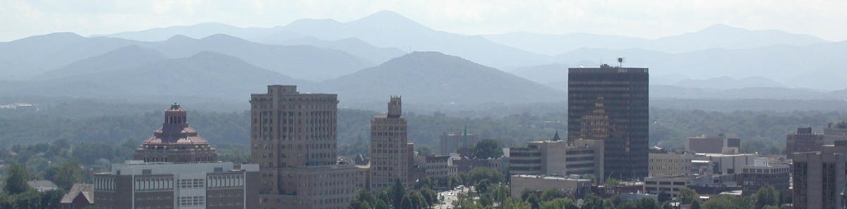 Downtown Asheville's classic Art Deco buildings rise against a background featuring Mt. Pisgah and its neighboring Blue Ridge peaks.