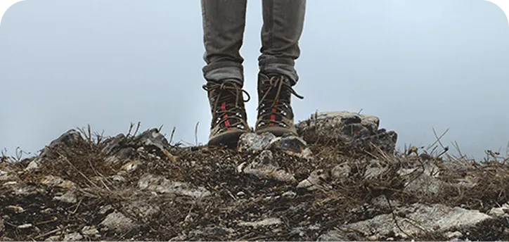 Man wearing boots on top of mountain