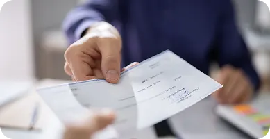 woman working on personal computer with a dslr camera next to her