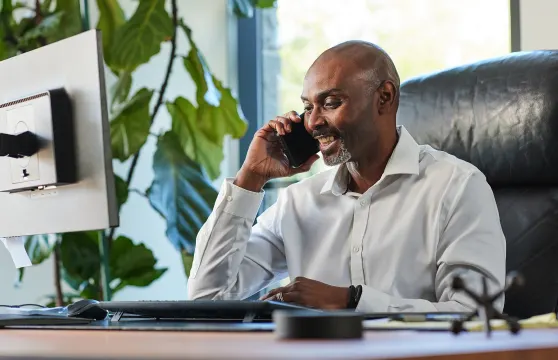 Man talking on his cellphone while sitting in his office