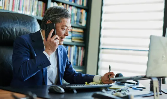 Man sitting at his desk in the office and is assisting his client
