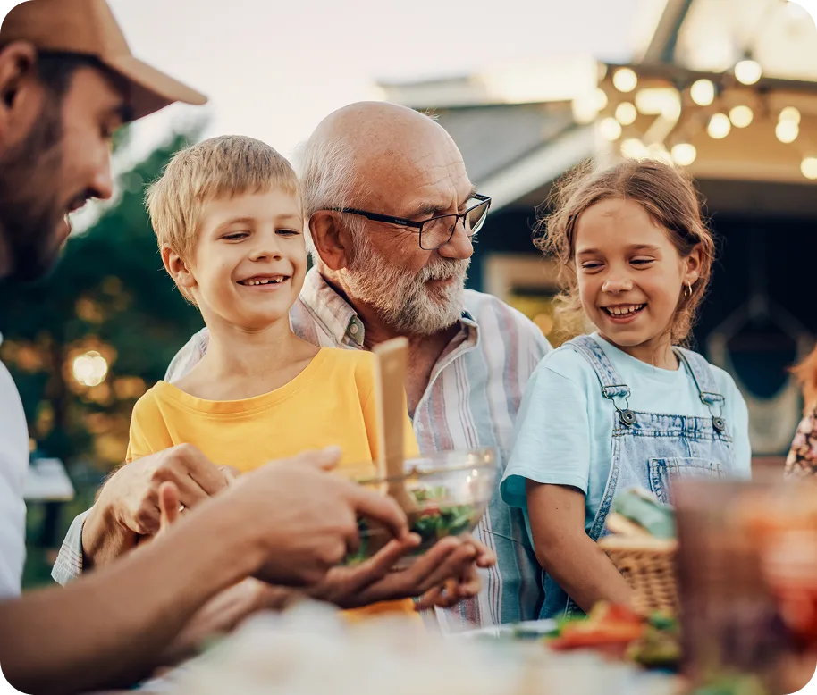 grandpa with glasses holding grandchildren