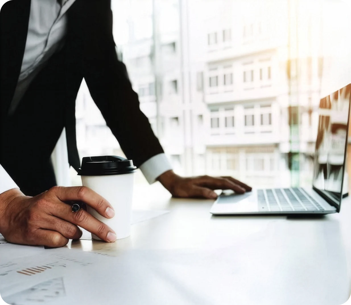 Man using computer at desk with coffee