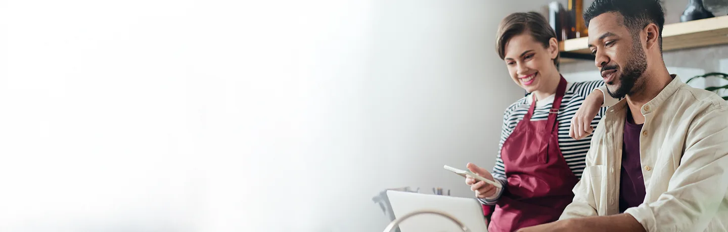 man and woman working on laptop smiling