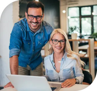 man and woman smiling toward the screen while working on paperwork