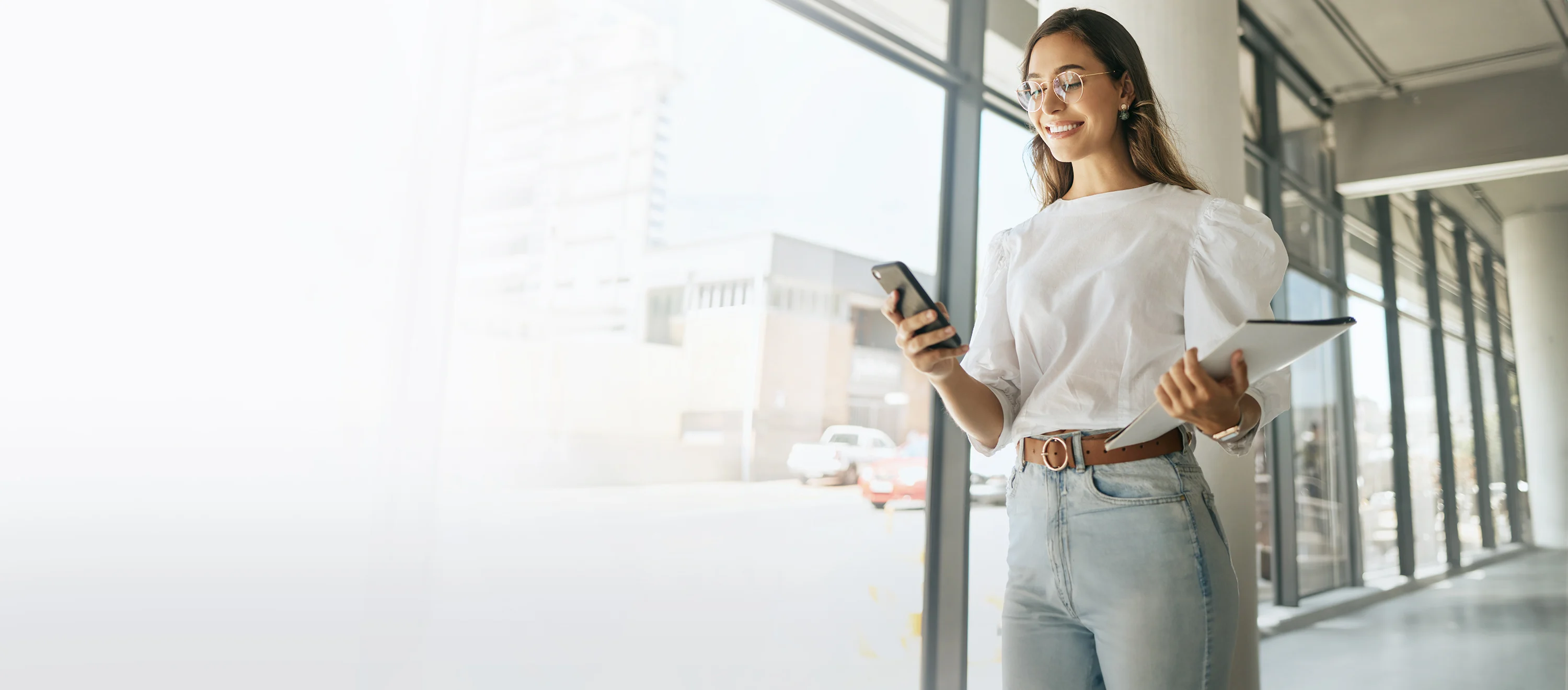 Woman walking down hallway with phone in hand