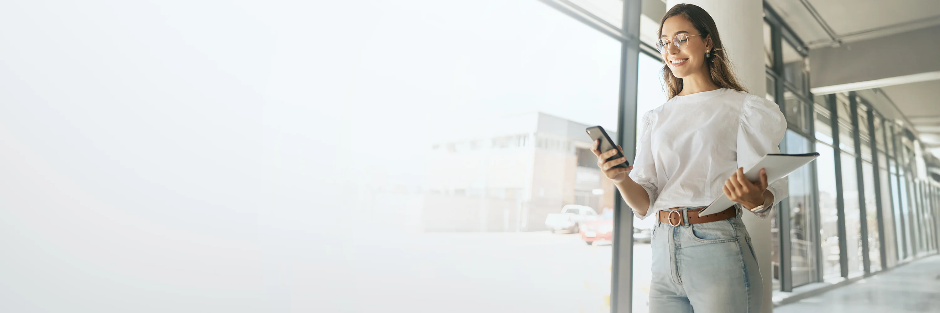 Woman walking down hallway with phone in hand