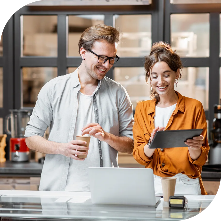Man with coffee talking to woman with table on hand