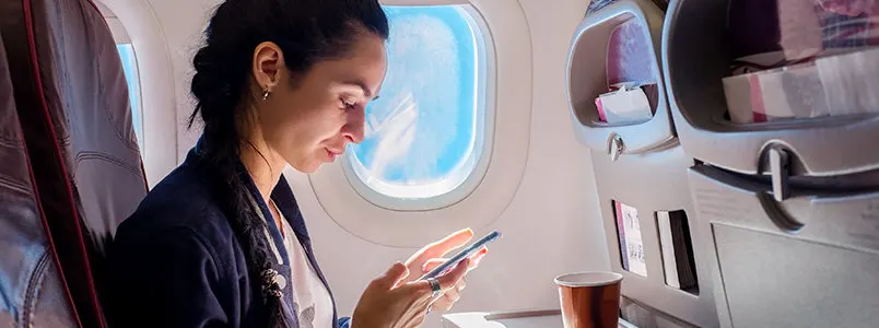 woman on airplane looking at phone