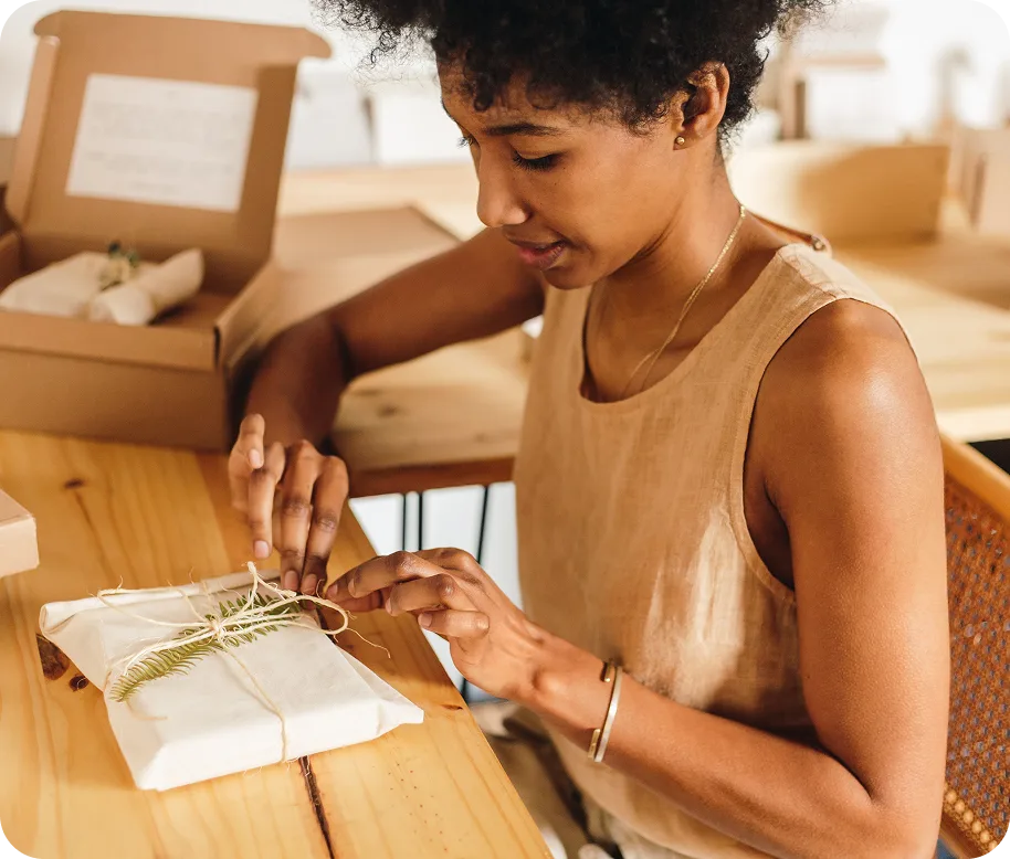 A lady wrapping gift at her desk