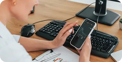 woman working on personal computer with a dslr camera next to her