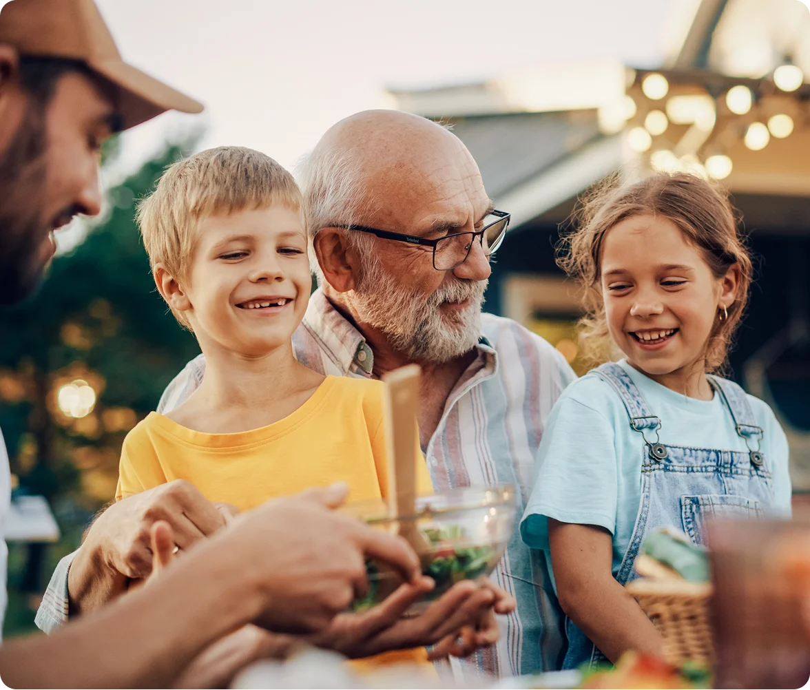 grandpa with glasses holding grandchildren