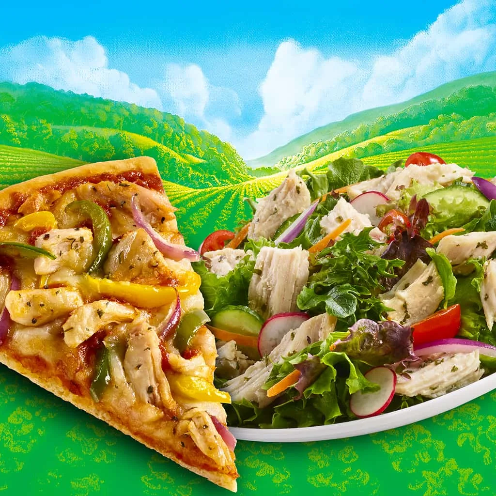 A slice of pizza and a plate of chicken and vegetables on a background of clouds and a valley