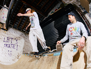 Stu Smith fine playing music on the Stockwell III in Cream next to a skater
