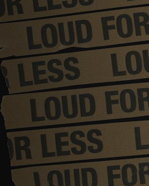 Gelbe Klebebänder mit der Aufschrift "LOUD FOR LESS".