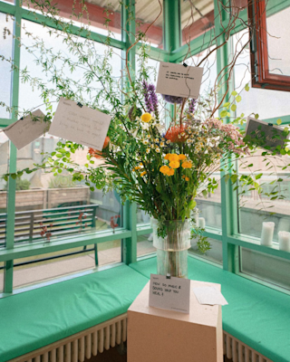 A vase filled with colorful flowers with envelopes containing messages
