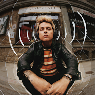 Billie listening to music on the Monitor III ANC black headphones whilst sitting at the doorsteps of a house.