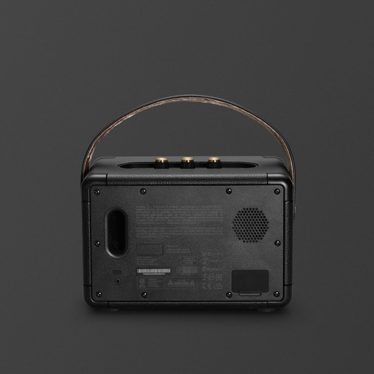 The portable speaker, Kilburn II Black and Brass, by Marshall, is a sleek black radio with a leather strap.