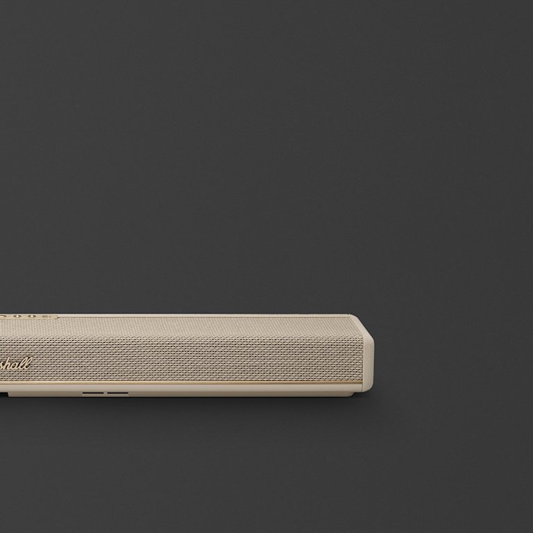 Marshall Heston 60 Cream soundbar with a textured front and gold accent, sits near the bottom left against a plain dark background.
