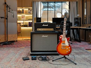 An electric guitar with Marshall amps in the background