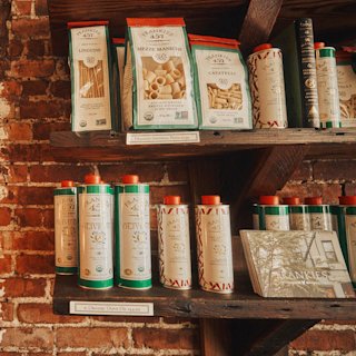 A shelf full of spices and pasta