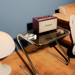 The Acton III Burgundy placed on top of a glass table