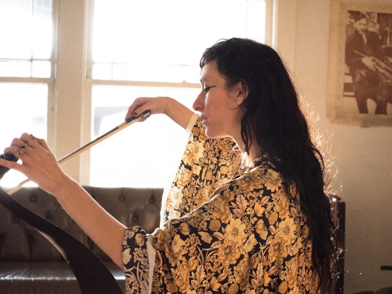 Zumi Rosow playing a harp.