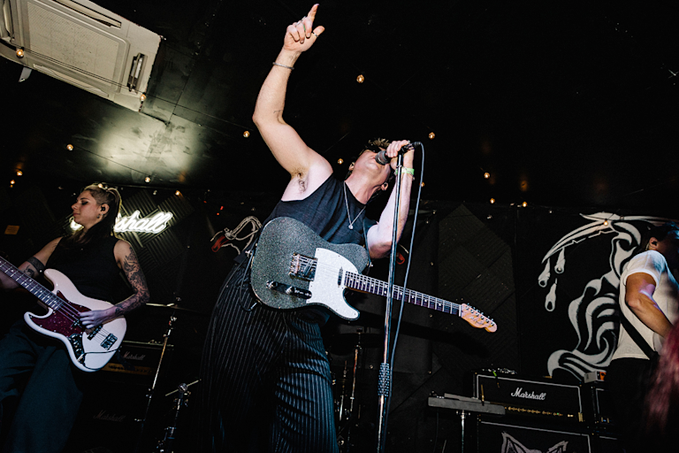 An artist performing live on stage with a band