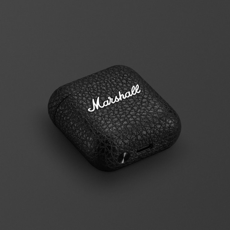 Marshall Minor IV Carging Case in Black laying on a dark background.