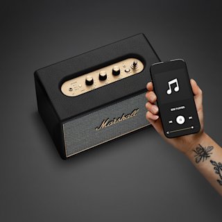 Smartphone next to Marshall Acton IV Black speaker.