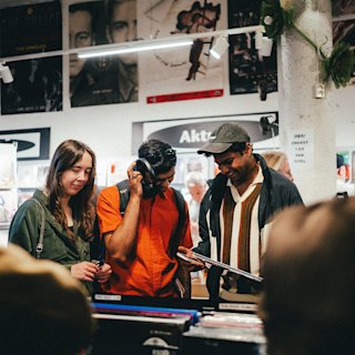 People browsing vinyls together with Marshall headphones